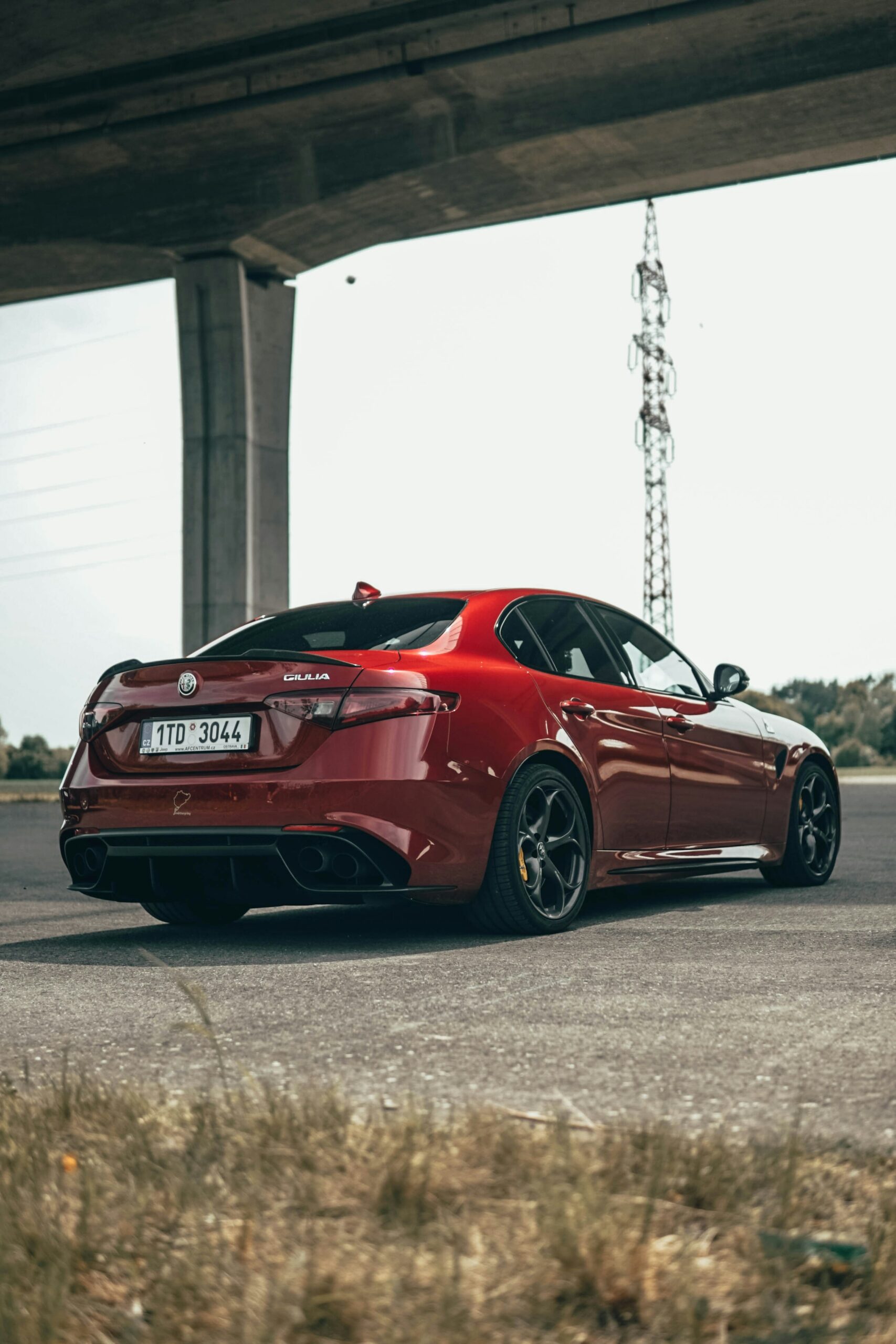 Red Alfa Romeo Giulia on the road, rear three-quarter view