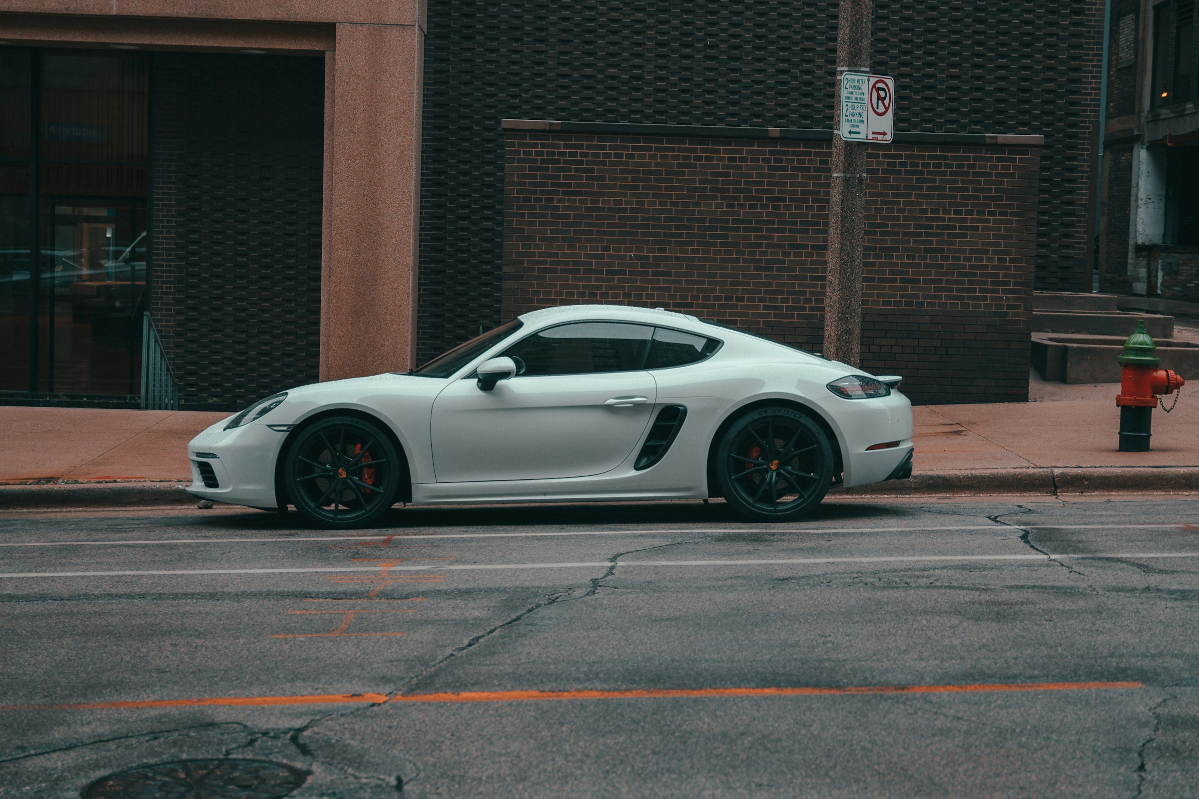 White Porsche 718 Cayman (982) parked kerbside on a city street